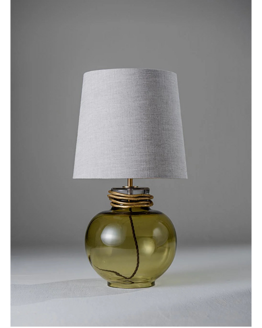 Table lamp with a green glass base and gray lampshade on a neutral background